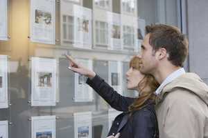 Young couple looking at an estate agent's window display