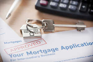 Approved mortgage loan application with house shaped keyring
