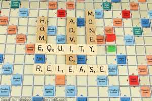 The phrase 'equity release' shown on a scrabble board