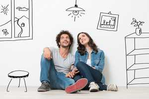 Young couple surrounded by cartoons depicting the contents of their dream home
