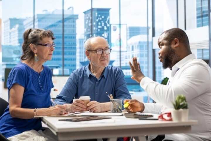 Senior couple discussing options with a financial adviser