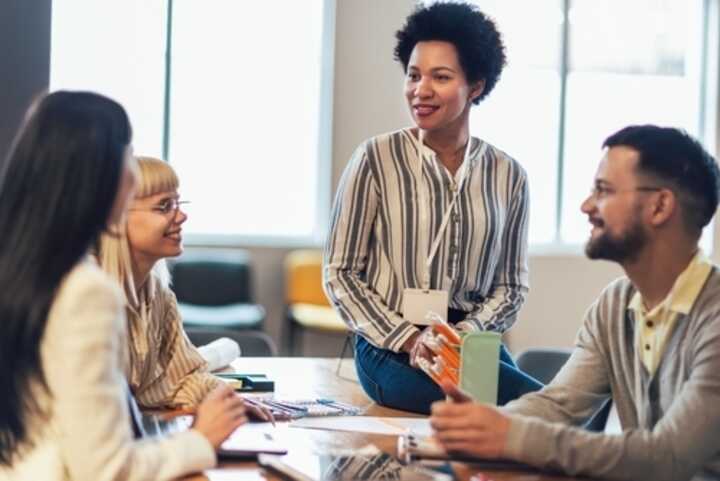 Four business colleagues engaged in a discussion at the office