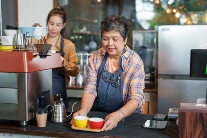 Senior woman serving in a coffee shop